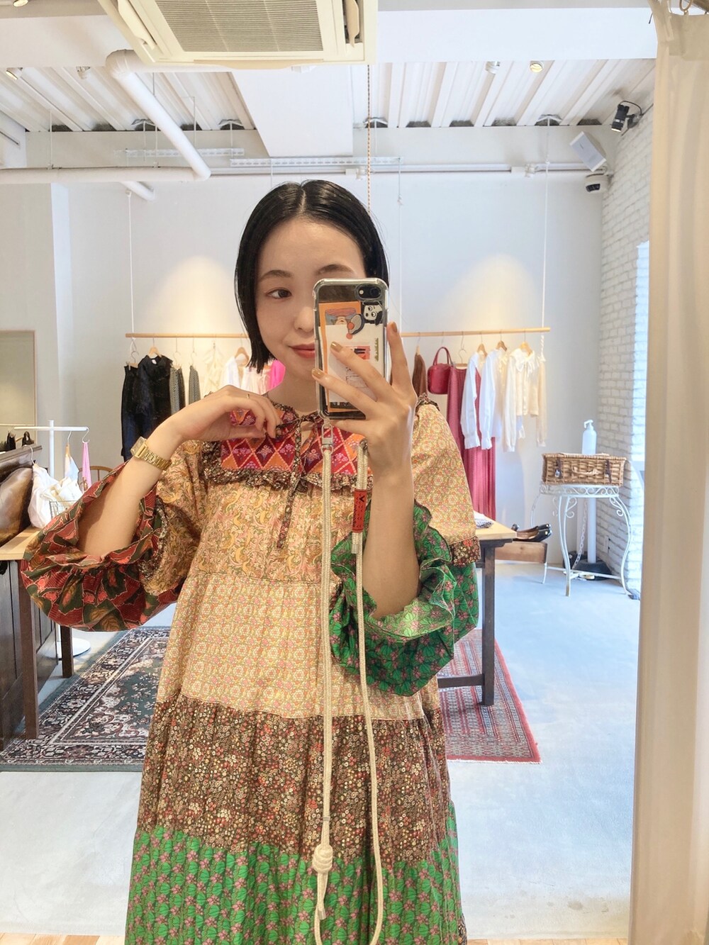 イエロー系のワンピース、グリーン系のスニーカーを着用したレディースの秋コーディネートの2枚目の写真