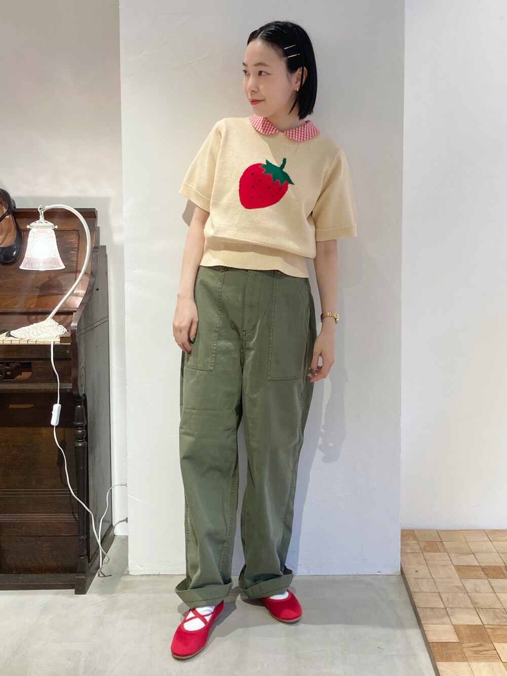 グリーン系のその他パンツ、ホワイト系のニット/セーター、レッド系のシャツ/ブラウスを着用したレディースの夏コーディネートの3枚目の写真