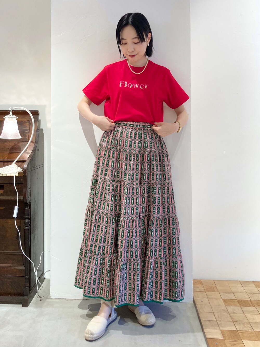 レッド系のTシャツ/カットソー、ピンク系のスカートを着用したレディースの春コーディネートの5枚目の写真