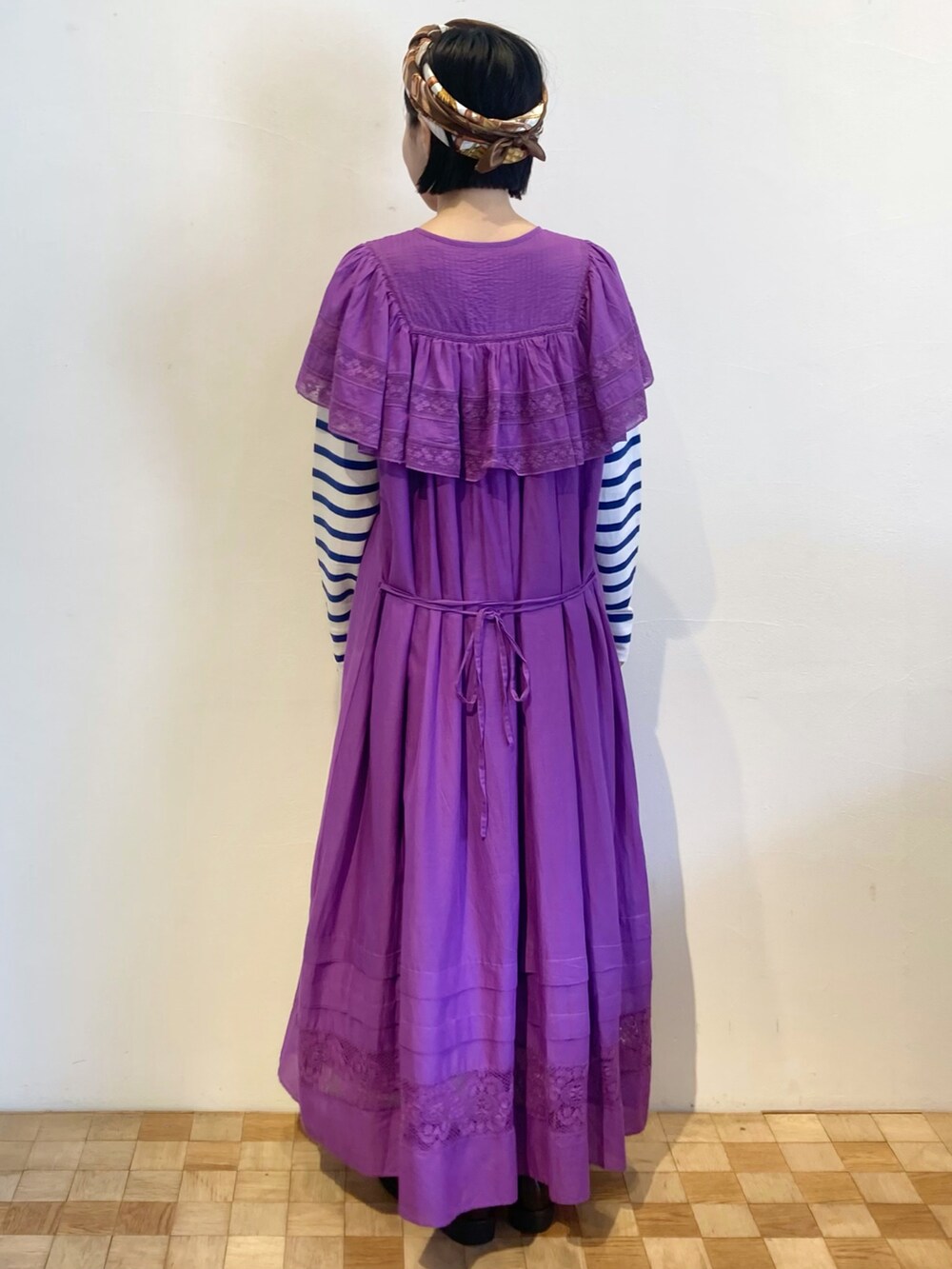 パープル系のワンピース、ブルー系のTシャツ/カットソーを着用したレディースの秋コーディネートの2枚目の写真