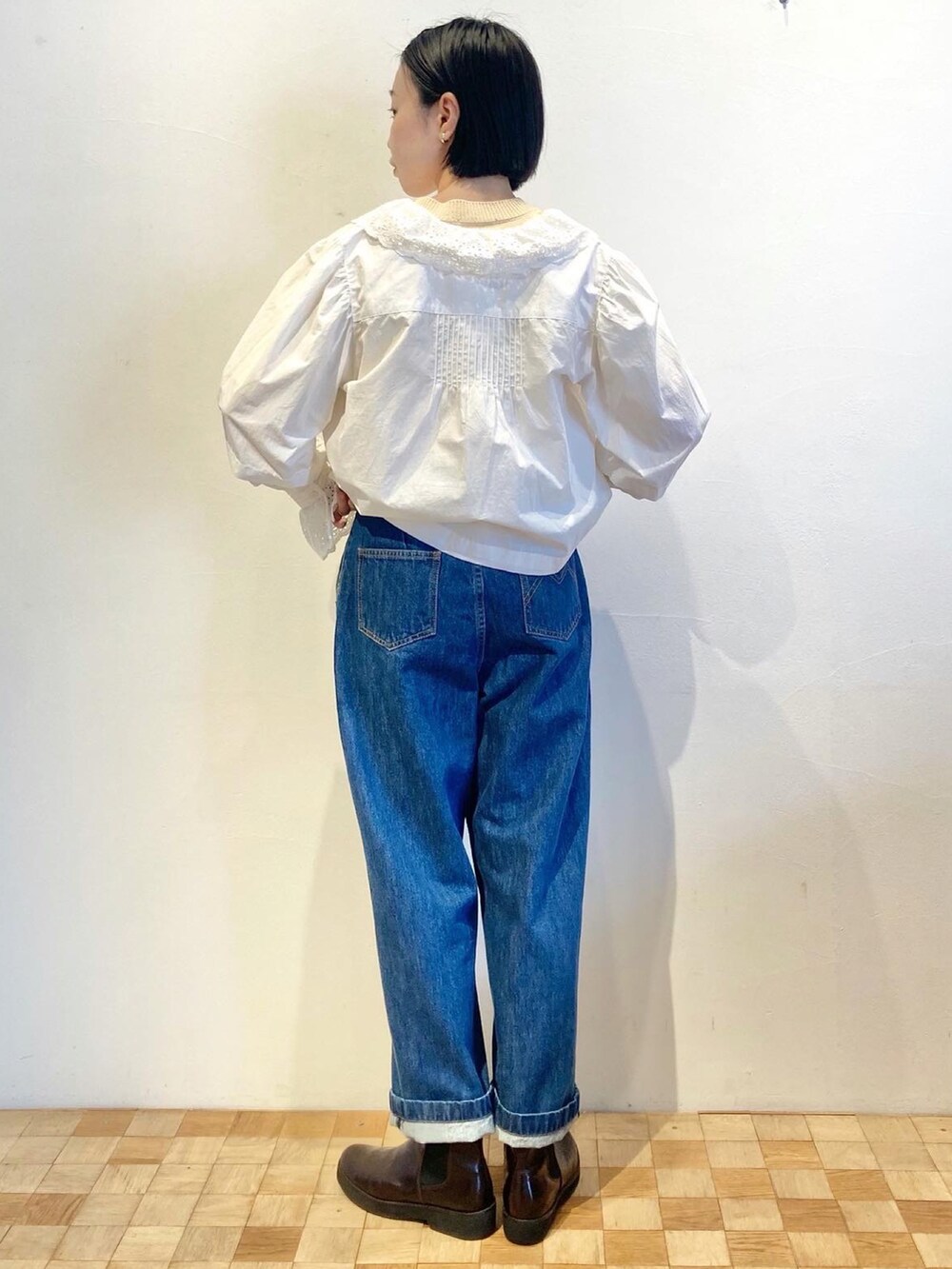 ブルー系のデニムパンツ、ホワイト系のシャツ/ブラウス、ブラウン系のブーツを着用したレディースの秋コーディネートの2枚目の写真