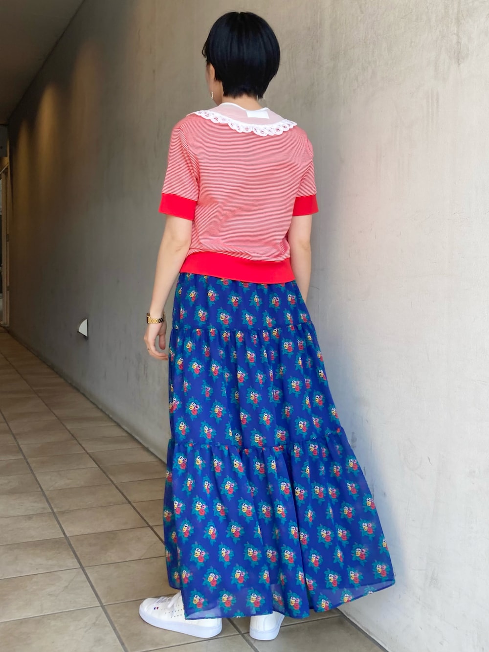 ブルー系のスカート、レッド系のTシャツ/カットソー、ホワイト系の付け襟を着用したレディースの春コーディネートの2枚目の写真