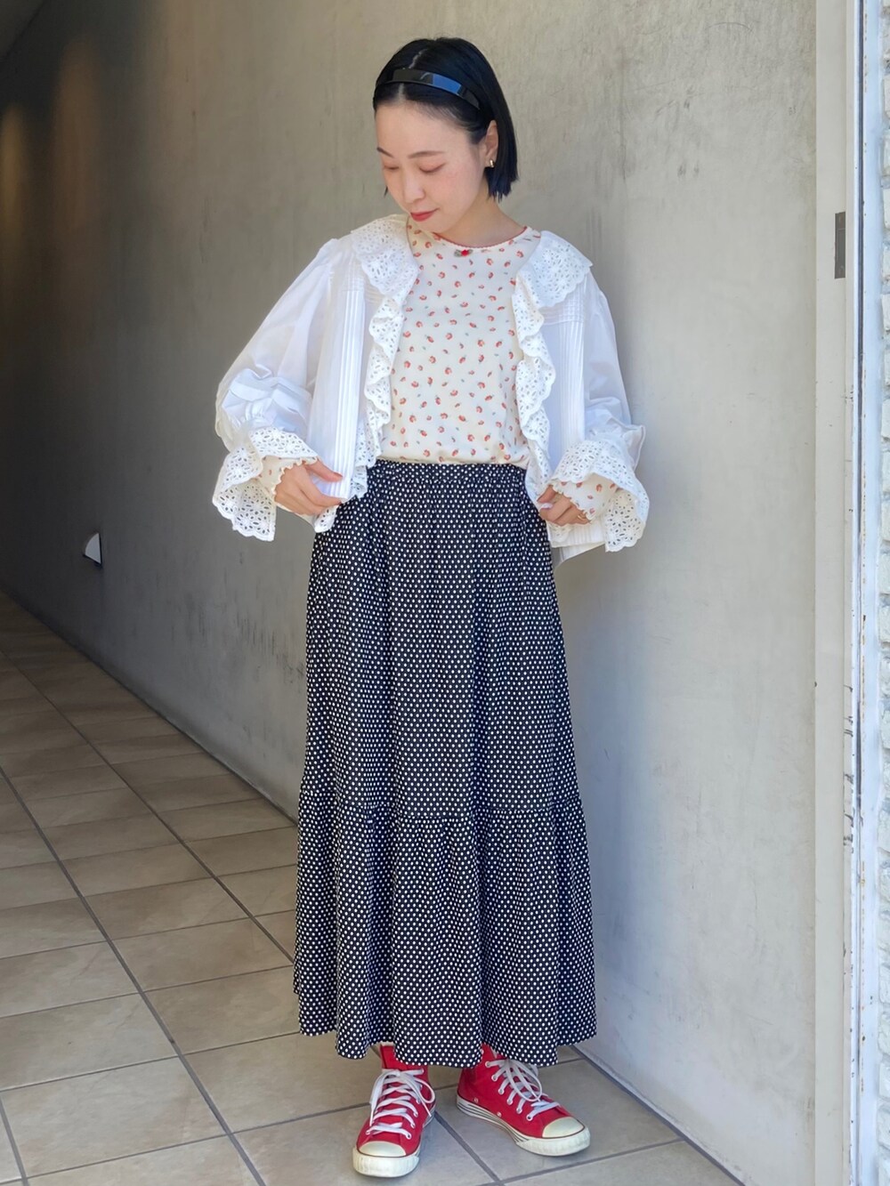 ブラック系のスカート、ホワイト系のシャツ/ブラウス、オレンジ系のTシャツ/カットソーを着用したレディースの秋コーディネートの2枚目の写真