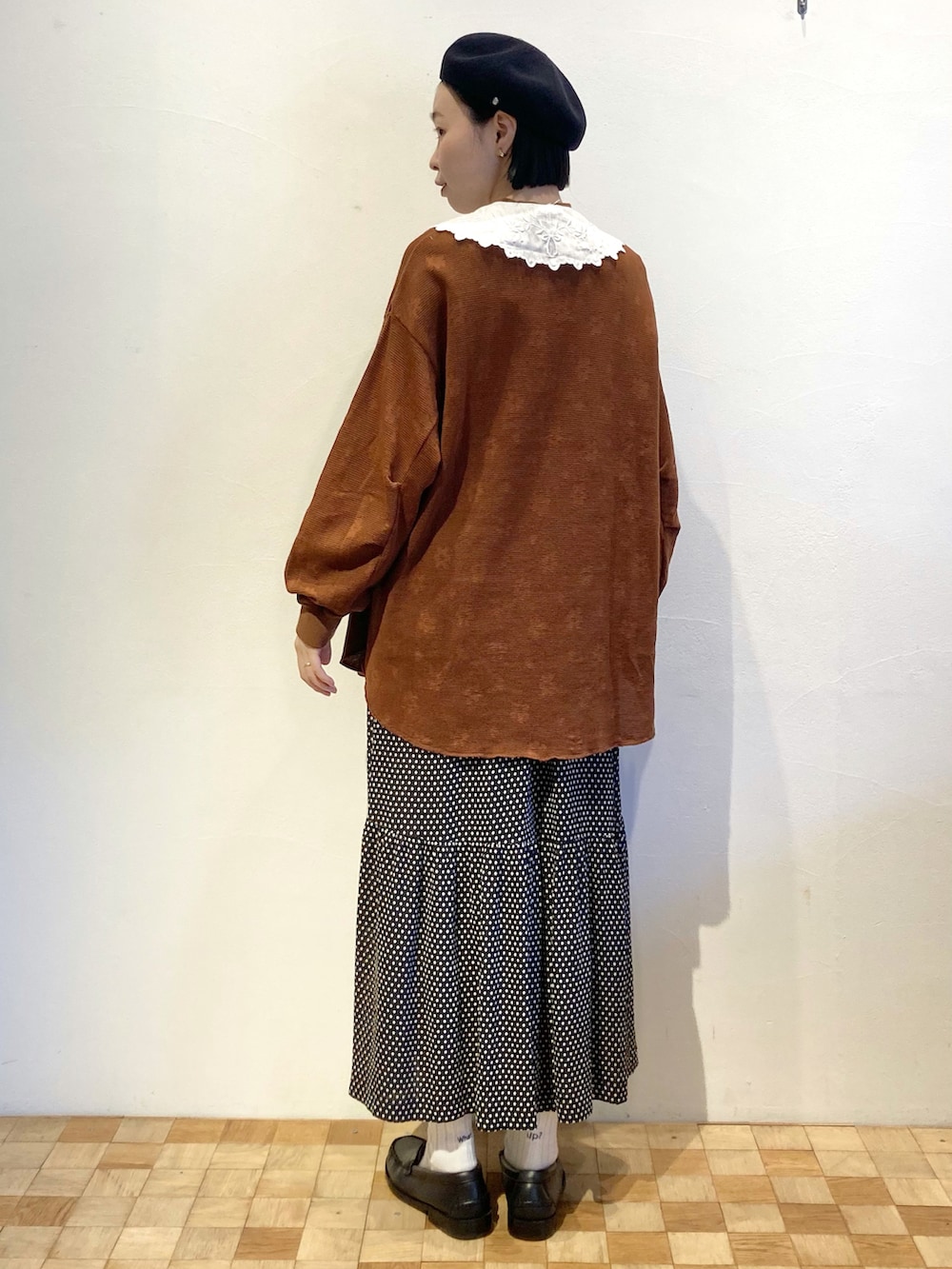 ブラック系のスカート、ブラウン系のTシャツ/カットソー、ホワイト系の付け襟を着用したレディースの秋コーディネートの3枚目の写真