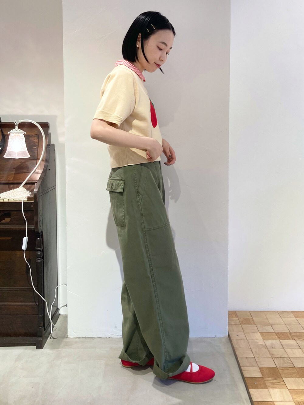 グリーン系のその他パンツ、ホワイト系のニット/セーター、レッド系のシャツ/ブラウスを着用したレディースの夏コーディネートの2枚目の写真