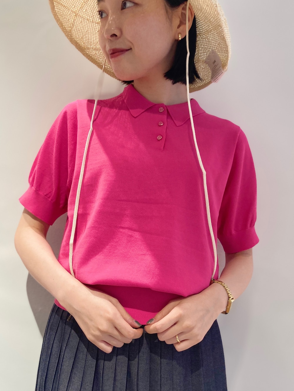 ピンク系のポロシャツ、ブルー系のデニムスカートを着用したレディースの夏コーディネートの5枚目の写真