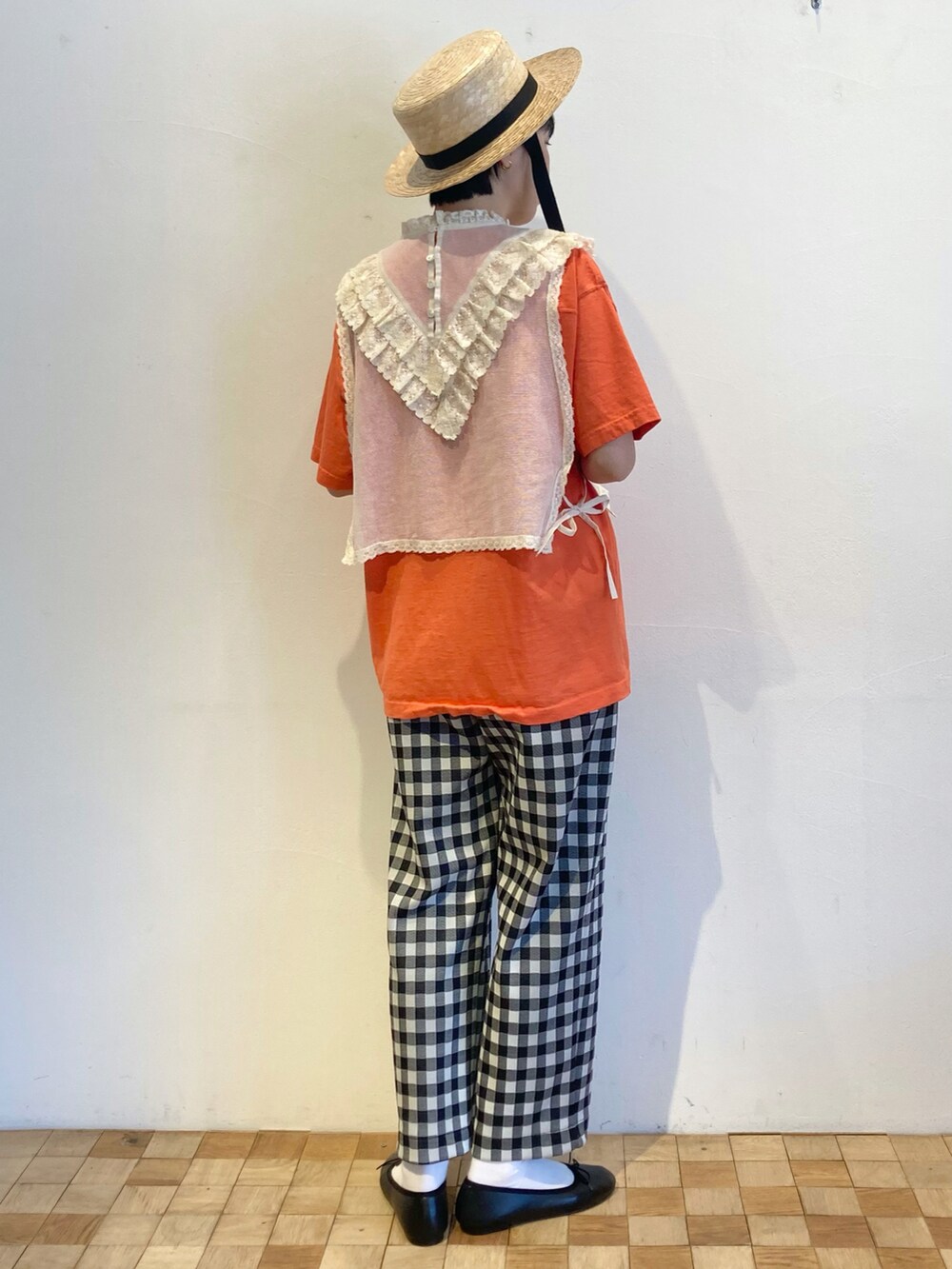 ブラック系のその他パンツ、ホワイト系のシャツ/ブラウス、オレンジ系のTシャツ/カットソーを着用したレディースの春コーディネートの2枚目の写真