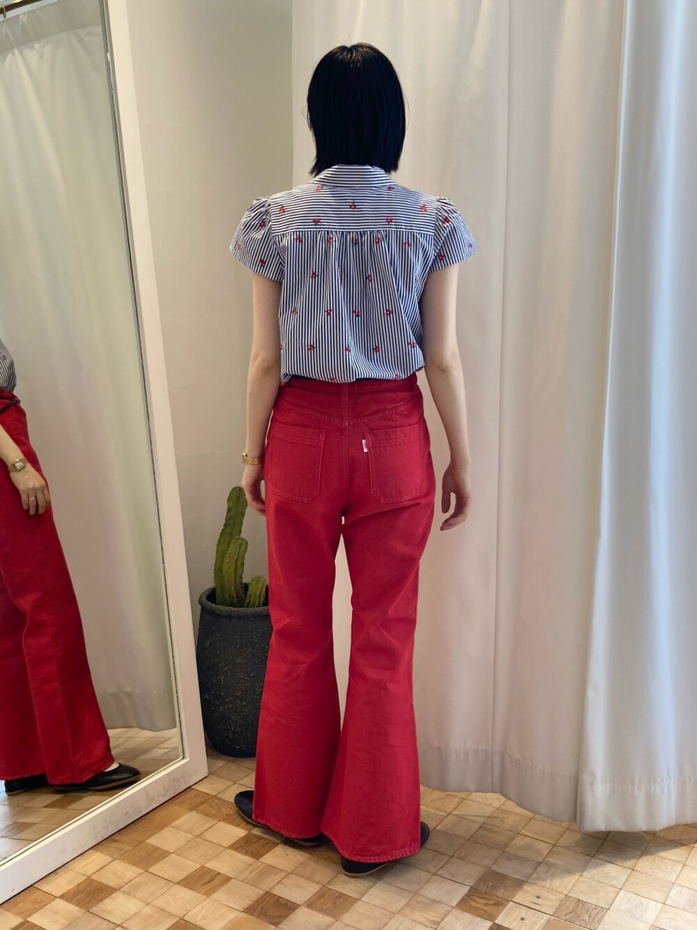 レッド系のデニムパンツ、ブルー系のシャツ/ブラウスを着用したレディースの夏コーディネートの2枚目の写真