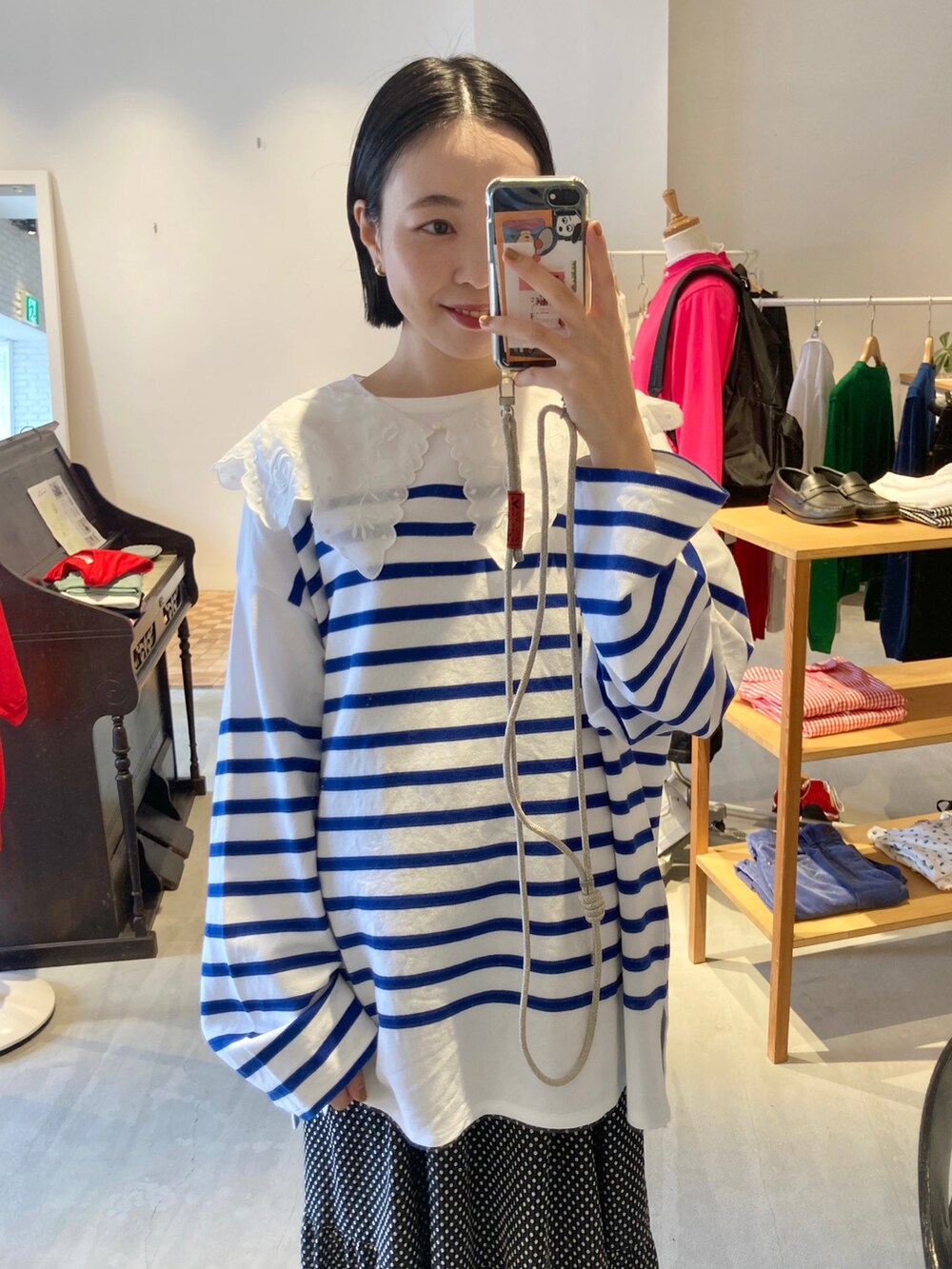 ブラック系のスカート、ブルー系のTシャツ/カットソー、ブルー系のスニーカーを着用したレディースの秋コーディネートの4枚目の写真