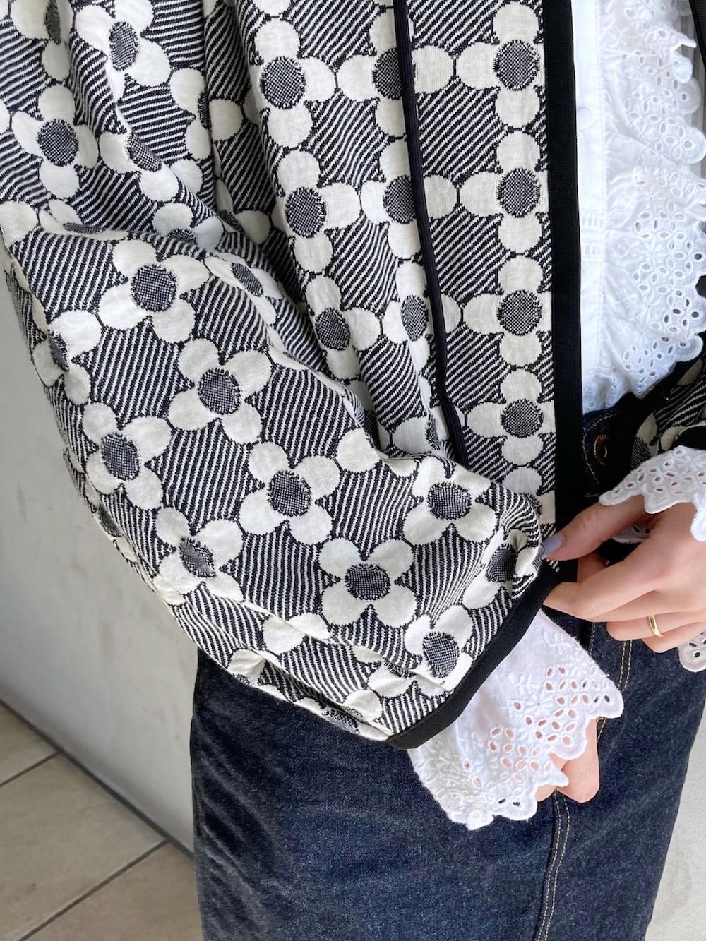 ブルー系のデニムスカート、ブラック系のカーディガン/ボレロ、ホワイト系のシャツ/ブラウスを着用したレディースの冬コーディネートの4枚目の写真