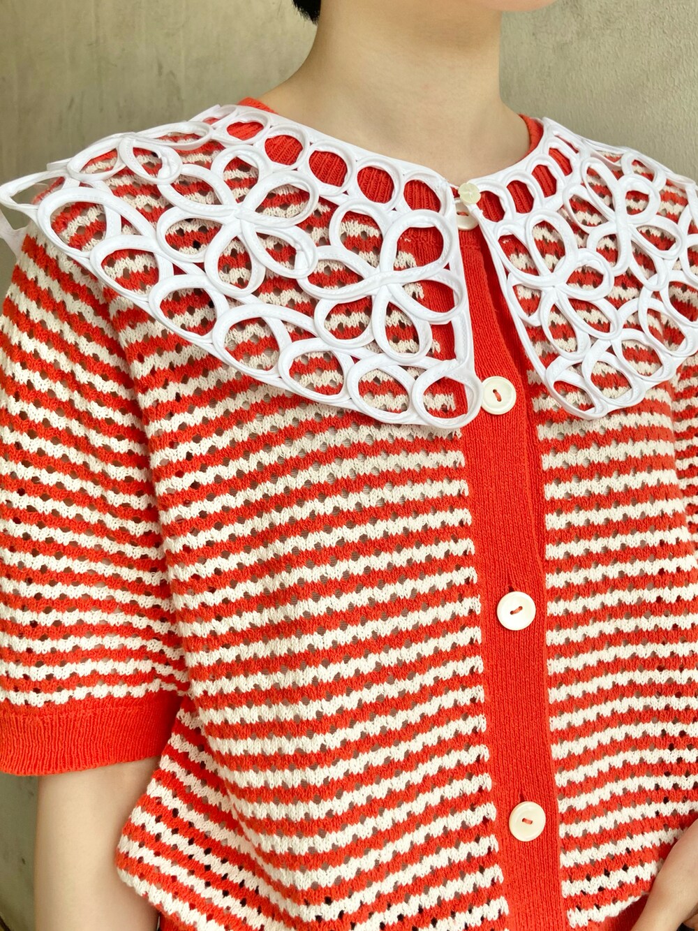 ブルー系のデニムスカート、レッド系のカーディガン/ボレロ、ホワイト系の付け襟を着用したレディースの春コーディネートの3枚目の写真