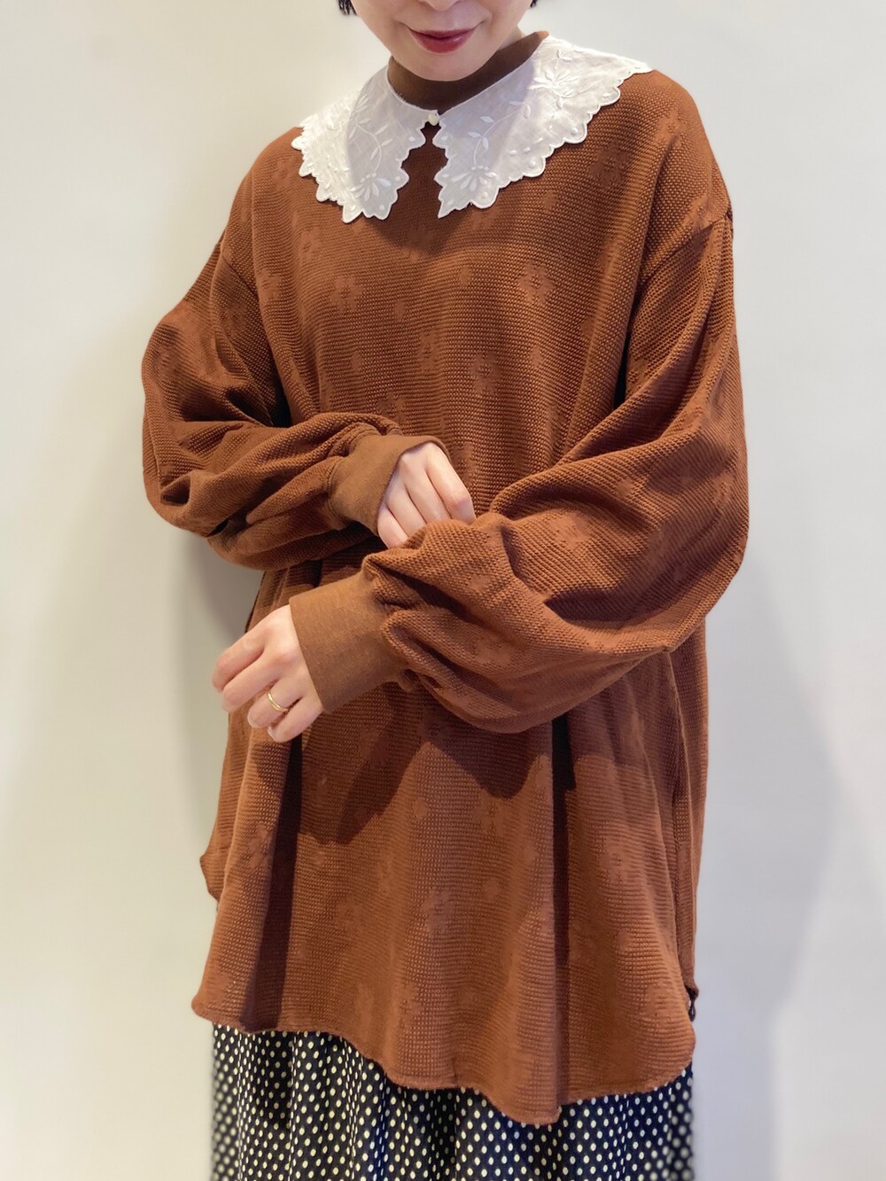 ブラック系のスカート、ブラウン系のTシャツ/カットソー、ホワイト系の付け襟を着用したレディースの秋コーディネートの4枚目の写真