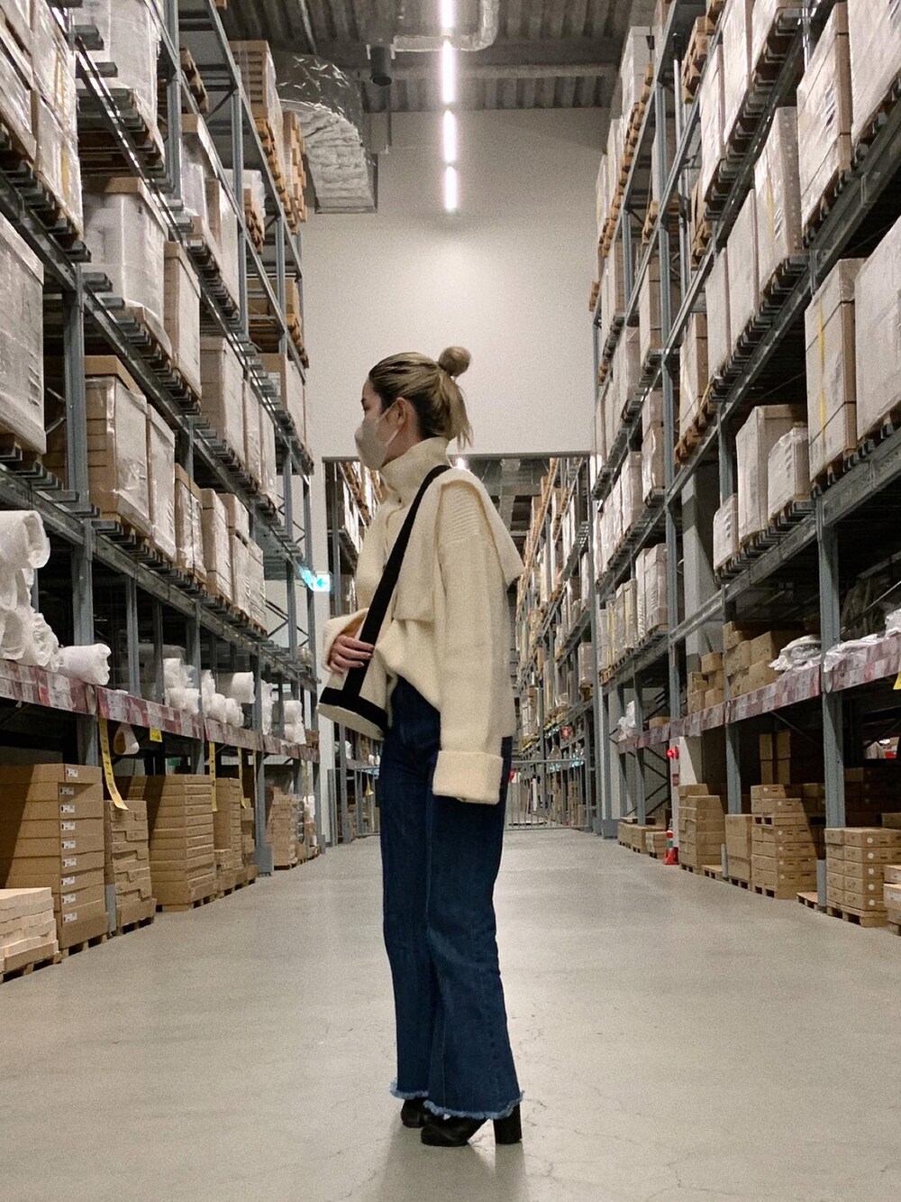 ホワイト系のニット/セーター、ブルー系のデニムパンツ、ブラック系のブーツを着用したレディースの冬コーディネートの2枚目の写真