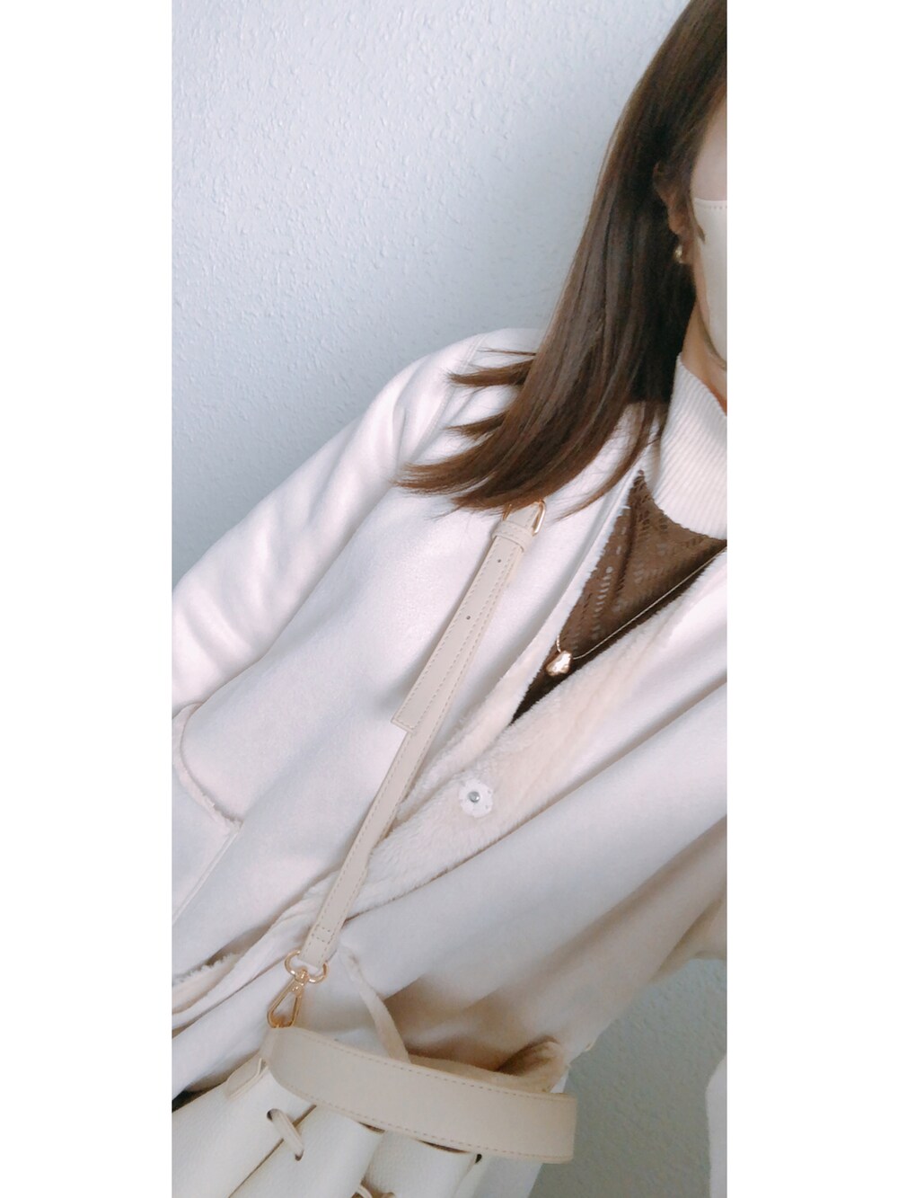 ブラウン系のスカート、ブラウン系のブーツ、ホワイト系のジャケット/アウターを着用したレディースの冬コーディネートの2枚目の写真