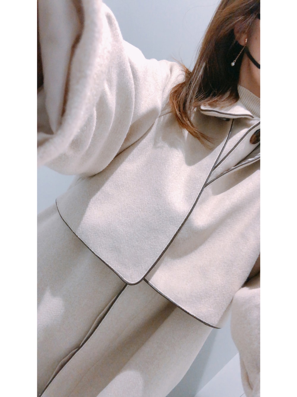 ベージュ系のジャケット/アウター、ホワイト系のアームカバーを着用したレディースの冬コーディネートの2枚目の写真