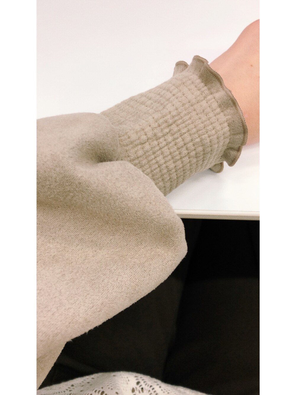 ベージュ系のトップス、ホワイト系のベスト、ブラウン系のパンツを着用したレディースの冬コーディネートの2枚目の写真