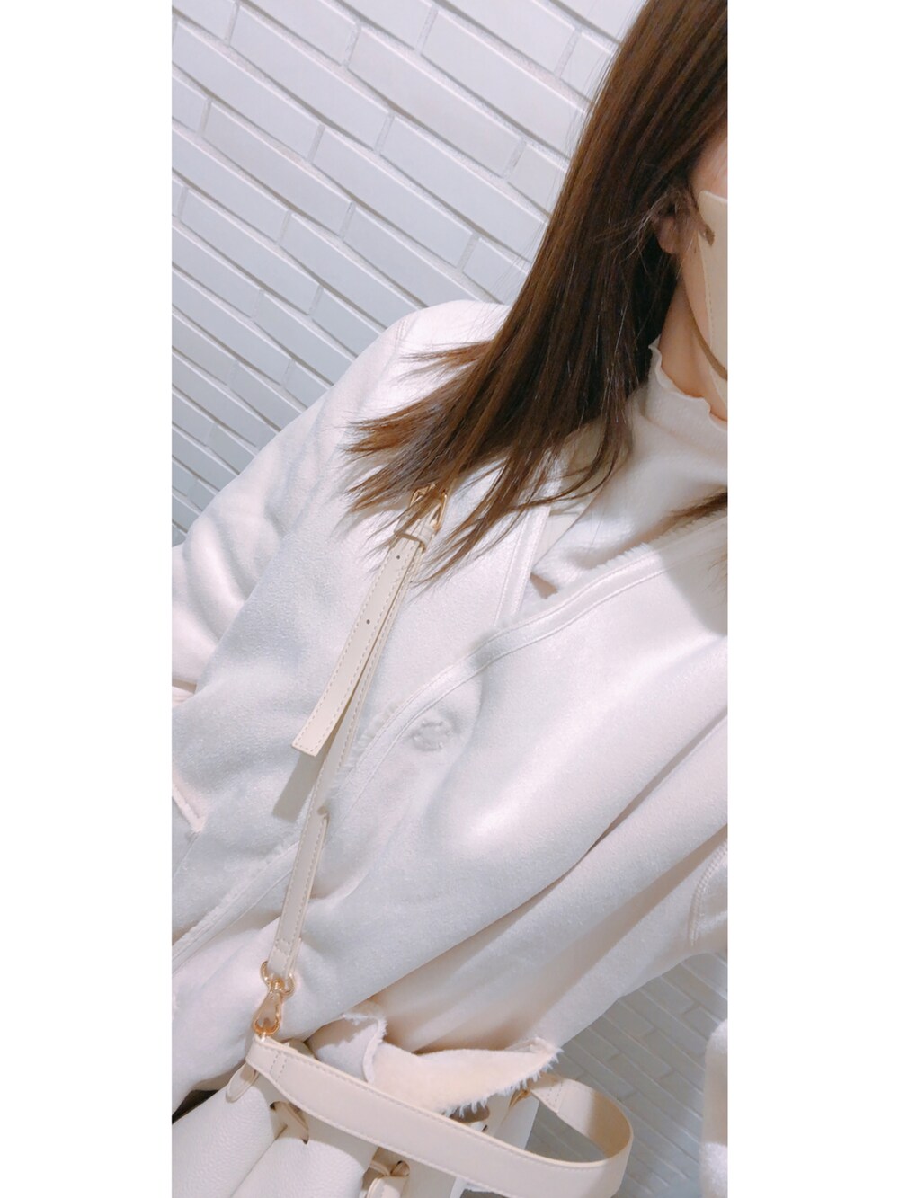 ホワイト系のトップス、ホワイト系のベスト、グレー系のスカートを着用したレディースの冬コーディネートの2枚目の写真