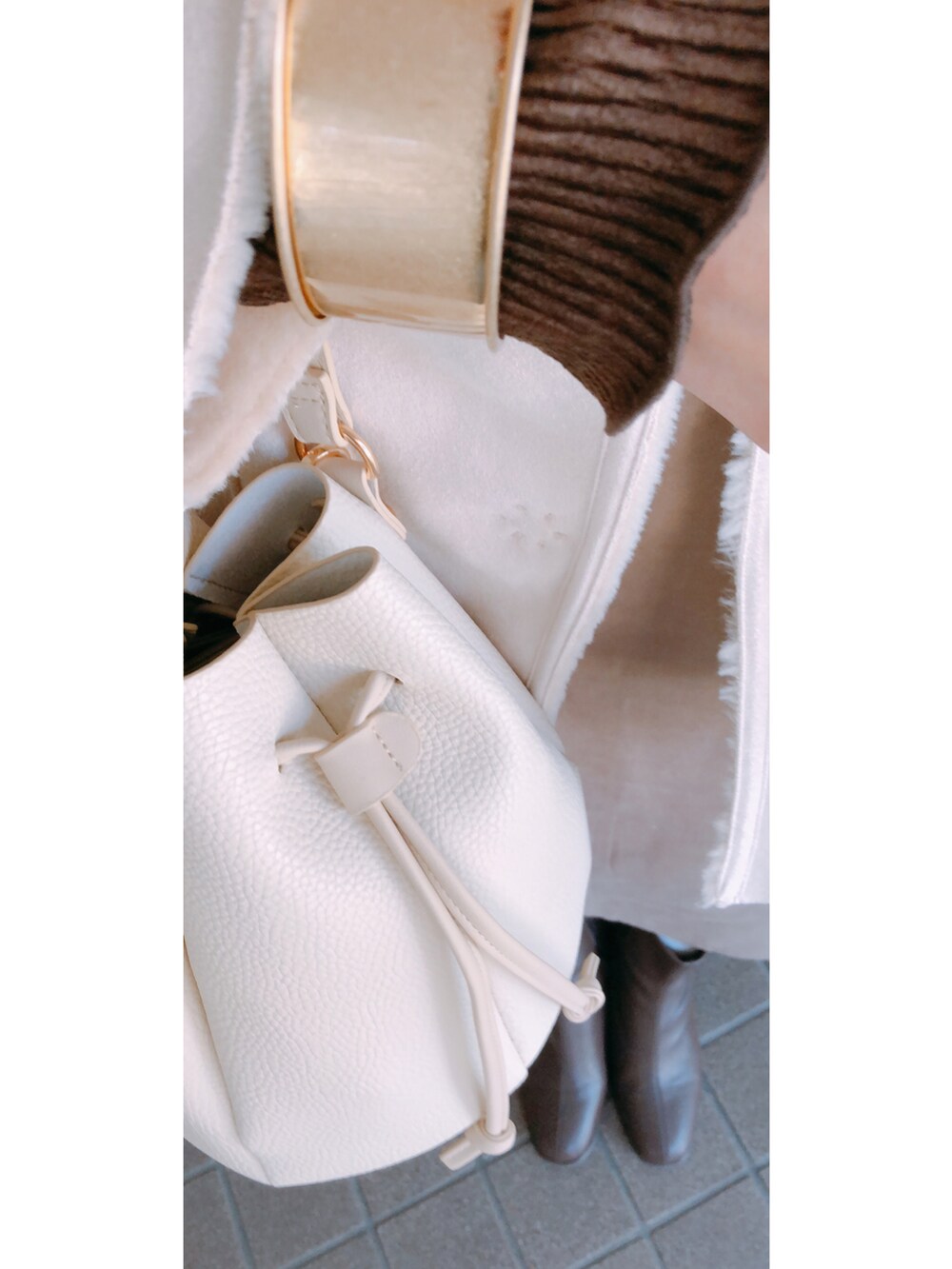 ブラウン系のトップス、ベージュ系のワンピース/ドレス、ホワイト系のジャケット/アウターを着用したレディースの冬コーディネートの3枚目の写真