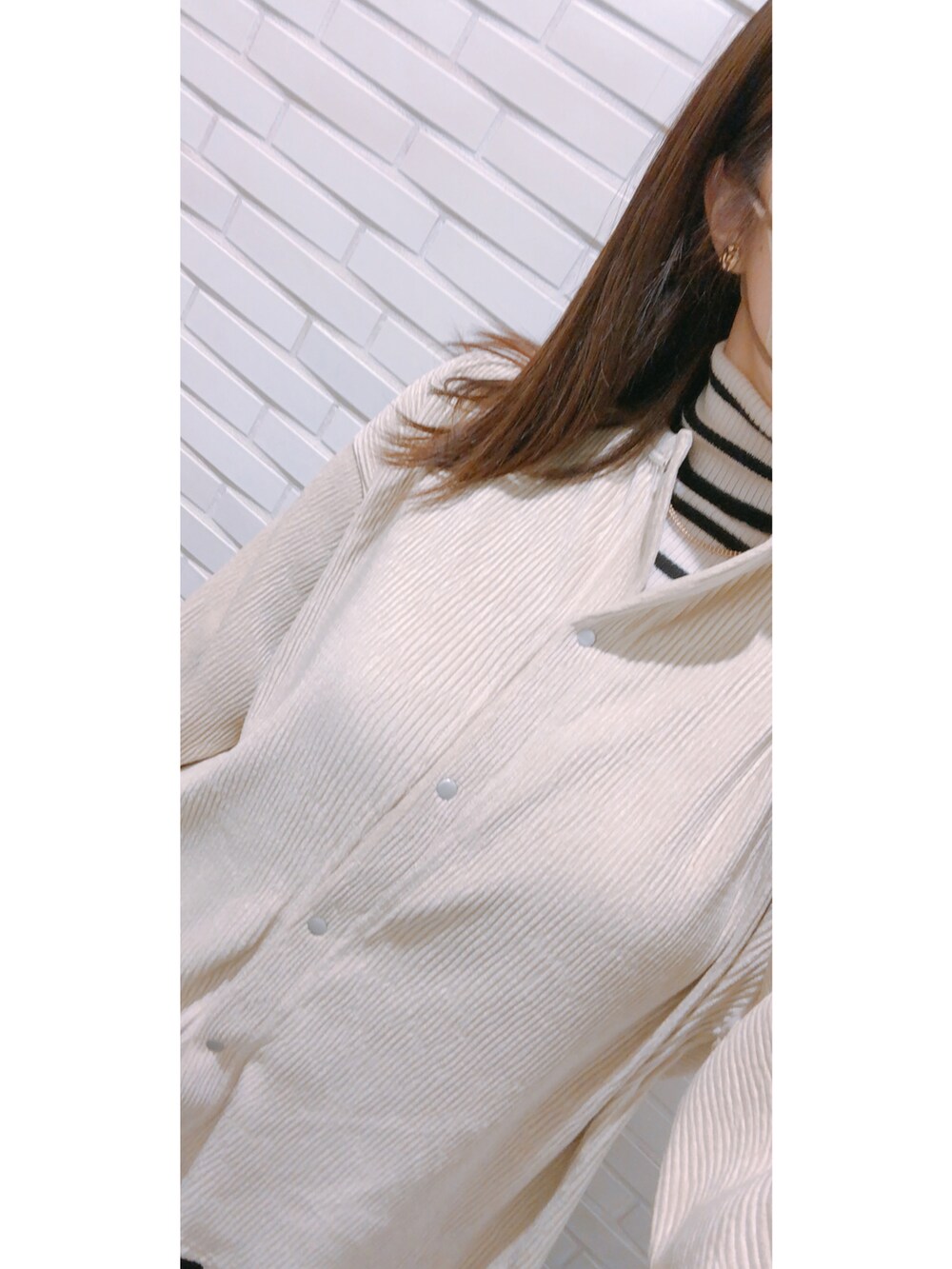 ブラック系のパンツ、ブラック系のパンプス、ホワイト系のバッグを着用したレディースの冬コーディネートの3枚目の写真