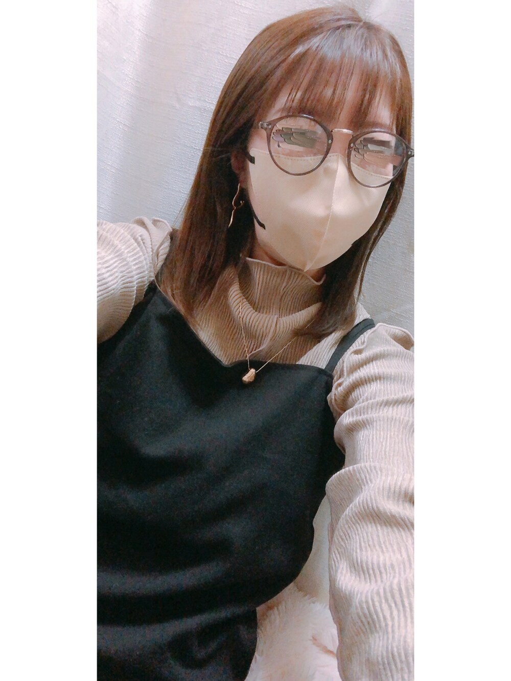 ホワイト系のダウンジャケット/コート、ブラック系のバッグ、ベージュ系のトップスを着用したレディースの冬コーディネートの3枚目の写真