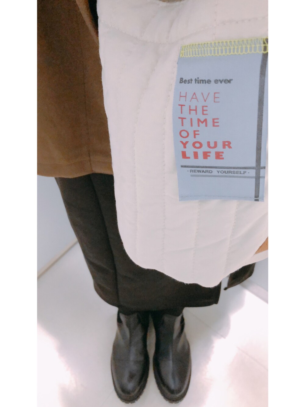 ブラック系のボストンバッグ、ホワイト系のブルゾン、ブラック系のスカートを着用したレディースの冬コーディネートの3枚目の写真