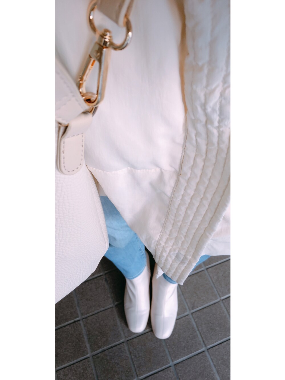 ホワイト系のトップス、ホワイト系のカーディガン/ボレロ、ホワイト系のバッグを着用したレディースの冬コーディネートの3枚目の写真