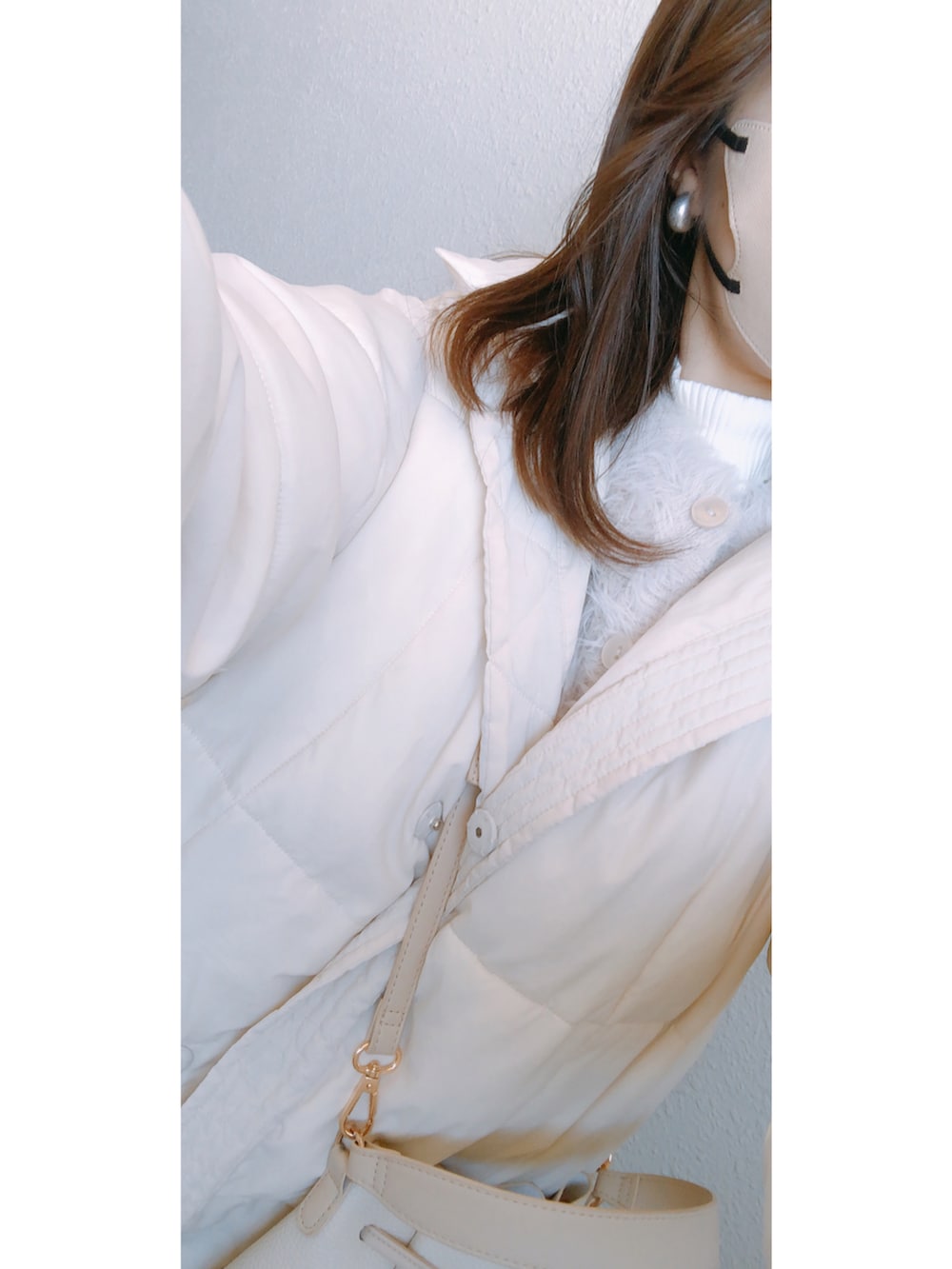 ホワイト系のトップス、ホワイト系のカーディガン/ボレロ、ホワイト系のバッグを着用したレディースの冬コーディネートの2枚目の写真