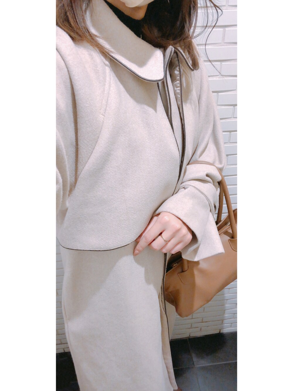 ブラウン系のバッグ、ブラウン系のシューズ、ブラック系のパンツを着用したレディースの冬コーディネートの2枚目の写真