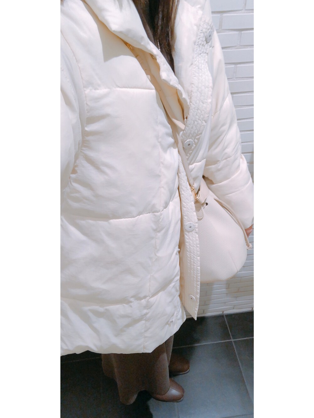 ホワイト系のカーディガン/ボレロ、ブラウン系のワンピース、ゴールド系のネックレスを着用したレディースの冬コーディネートの3枚目の写真