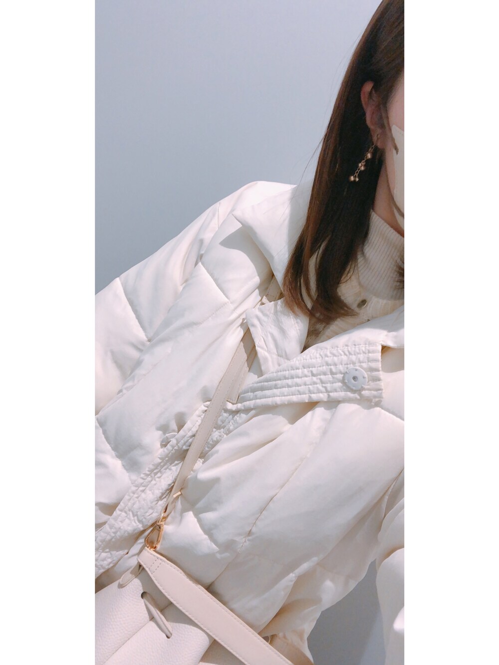 ブラウン系のカーディガン/ボレロ、ブラウン系のスカート、ゴールド系のイヤリングを着用したレディースの冬コーディネートの2枚目の写真