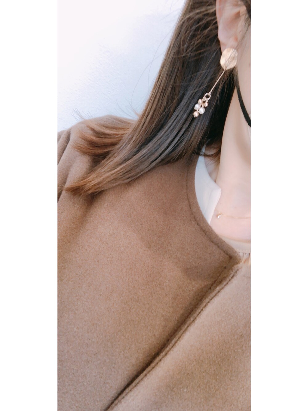 ブラウン系のノーカラーコート、ブラウン系のバッグ、ベージュ系のワンピース/ドレスを着用したレディースの冬コーディネートの2枚目の写真