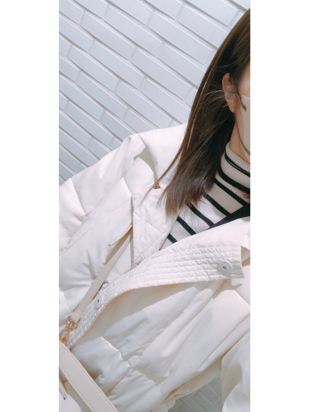 ブラック系のジャンパースカート、ホワイト系のニット/セーターを着用したレディースの冬コーディネートの2枚目の写真