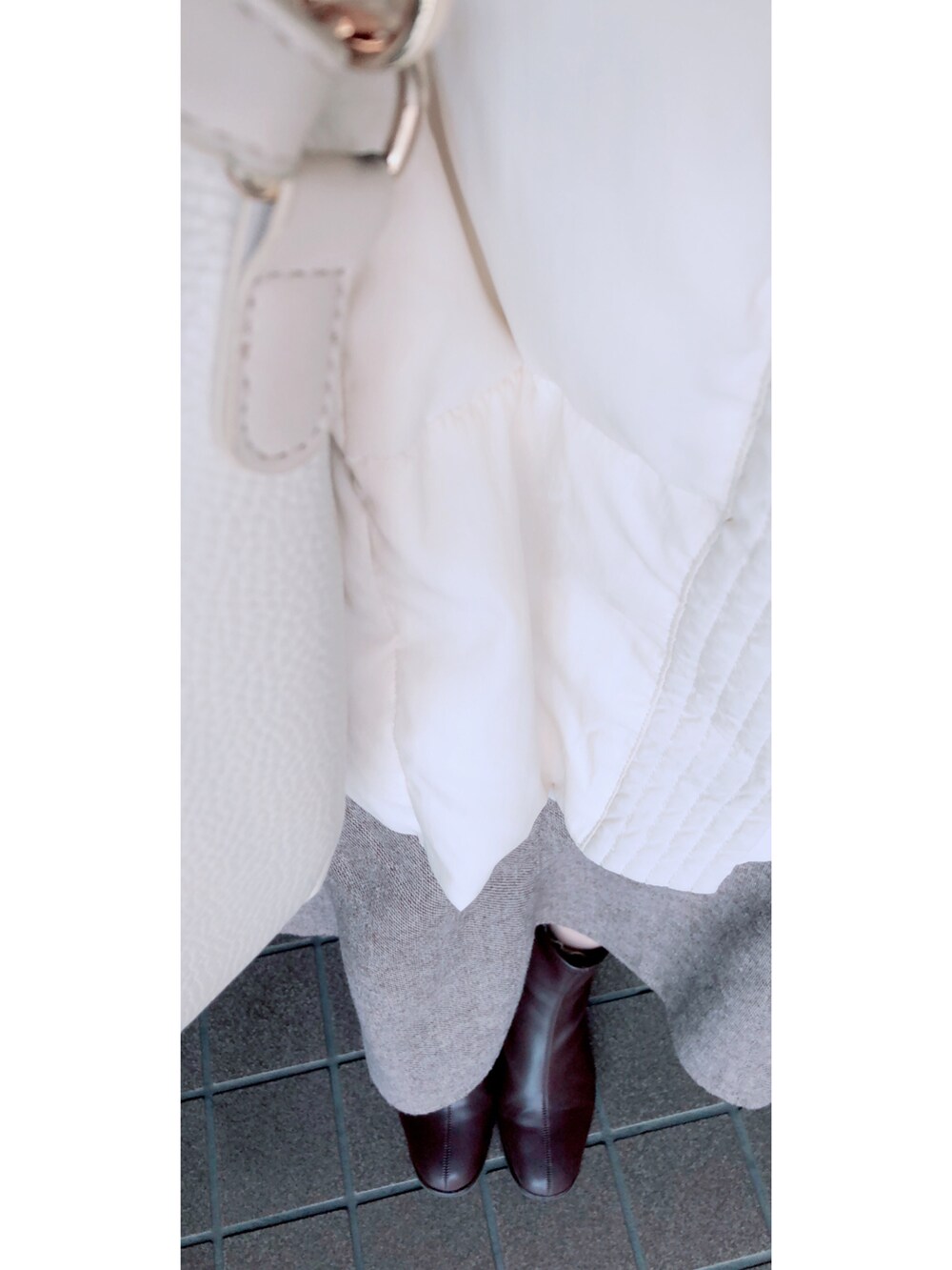 ホワイト系のダウンジャケット/コート、ホワイト系のバッグ、ブラウン系のスカートを着用したレディースの冬コーディネートの2枚目の写真