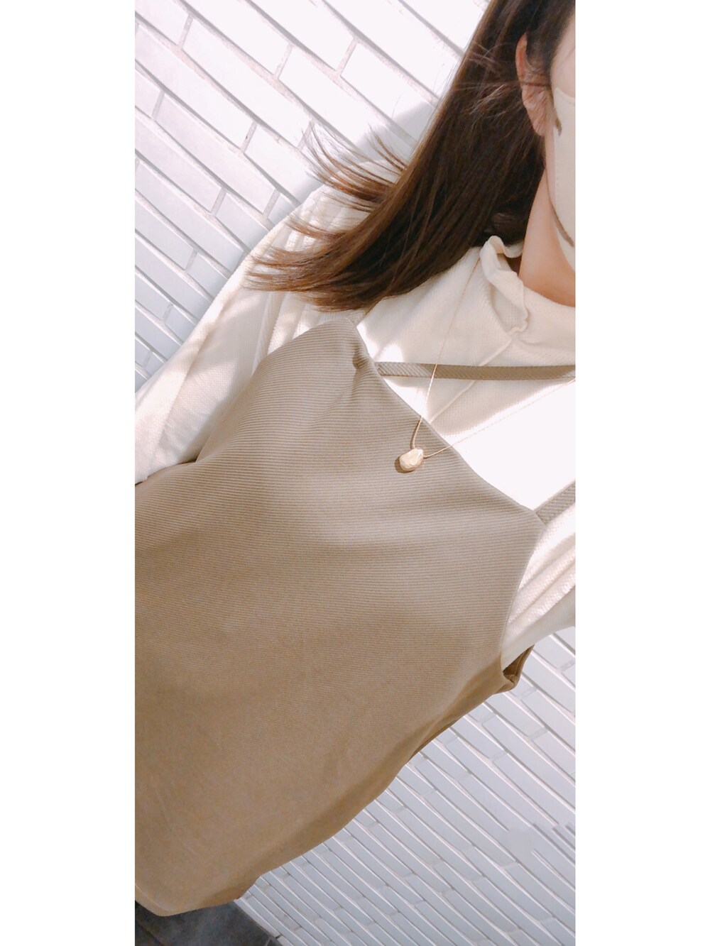 ホワイト系のトートバッグ、ホワイト系のバッグ、ホワイト系のトップスを着用したレディースの冬コーディネートの2枚目の写真