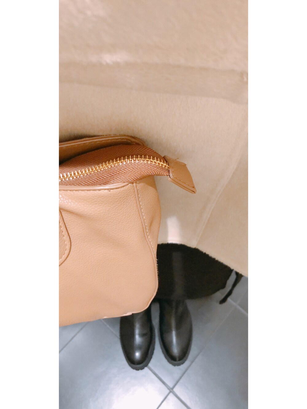 ホワイト系のニット/セーター、ホワイト系のベスト、ブラウン系のバッグを着用したレディースの冬コーディネートの2枚目の写真