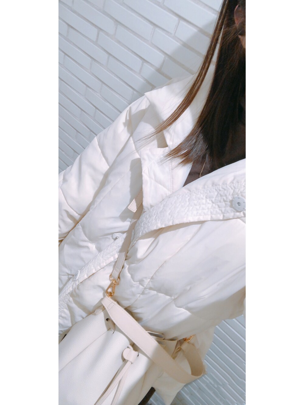 ホワイト系のカーディガン/ボレロ、ブラウン系のワンピース、ゴールド系のネックレスを着用したレディースの冬コーディネートの2枚目の写真