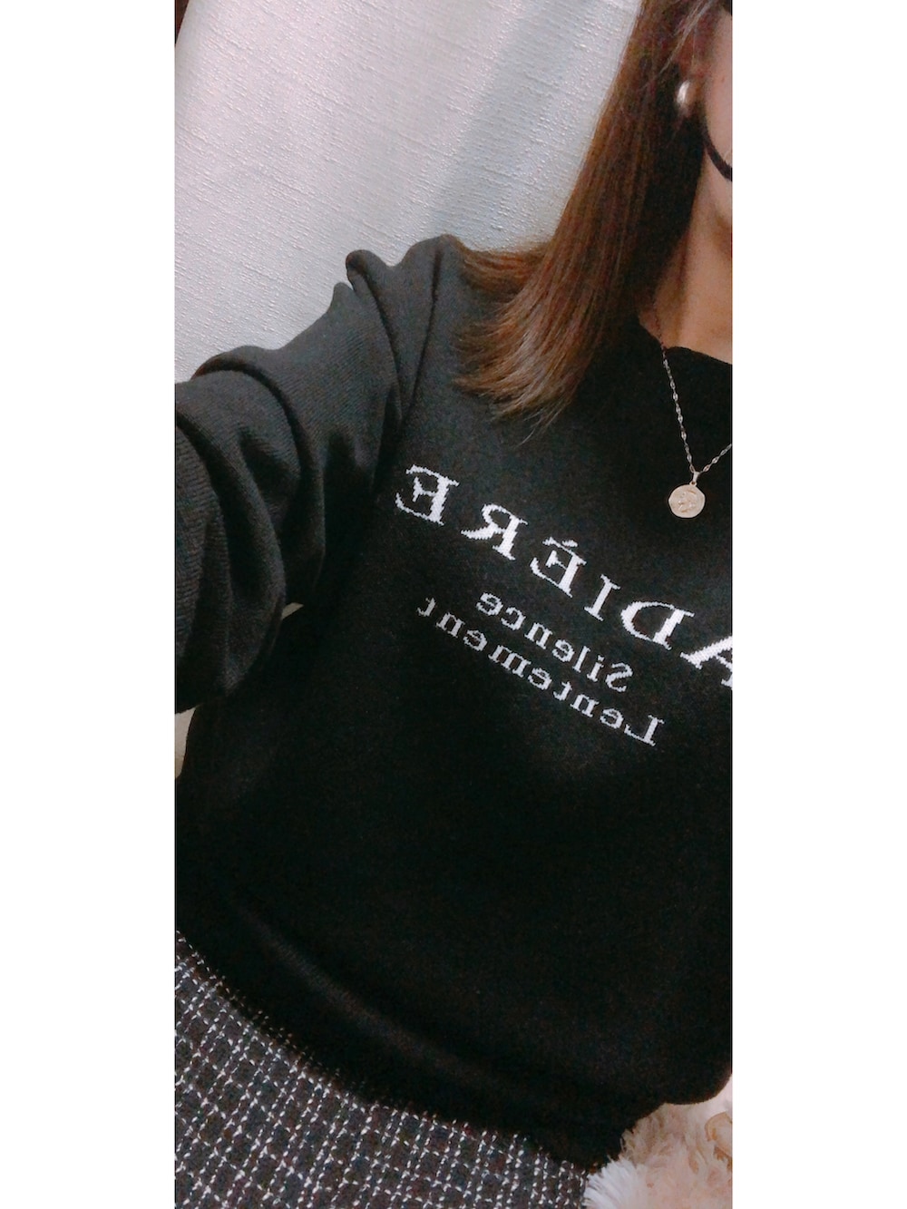 ブラック系のニット/セーター、ブラック系のスカート、ホワイト系のダウンジャケット/コートを着用したレディースの冬コーディネートの2枚目の写真