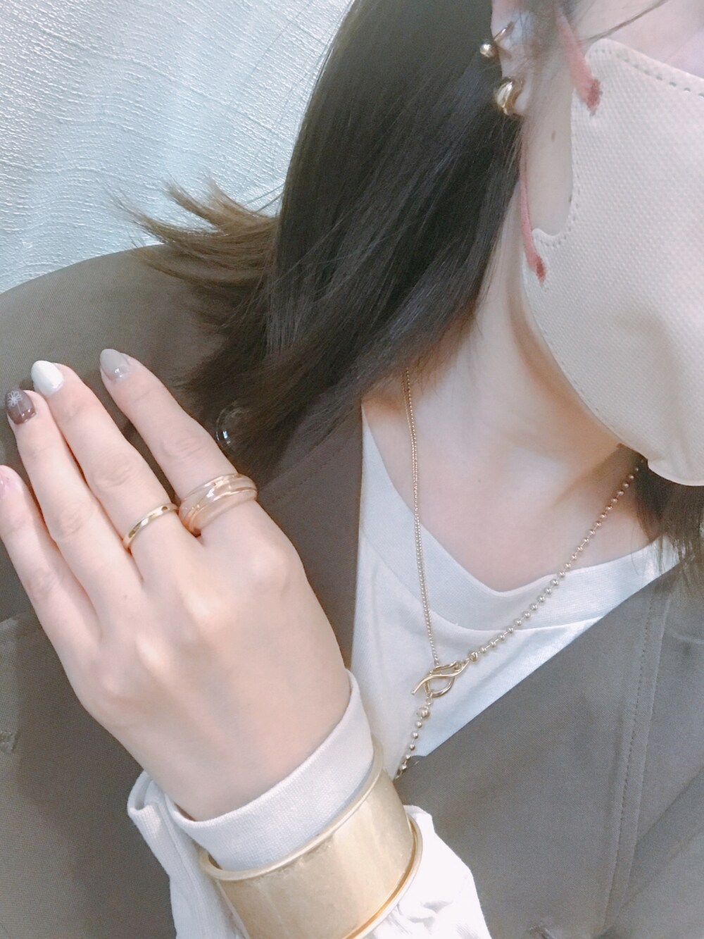 ホワイト系のバッグ、ブラウン系のベスト、ベージュ系のTシャツ/カットソーを着用したレディースの秋コーディネートの2枚目の写真