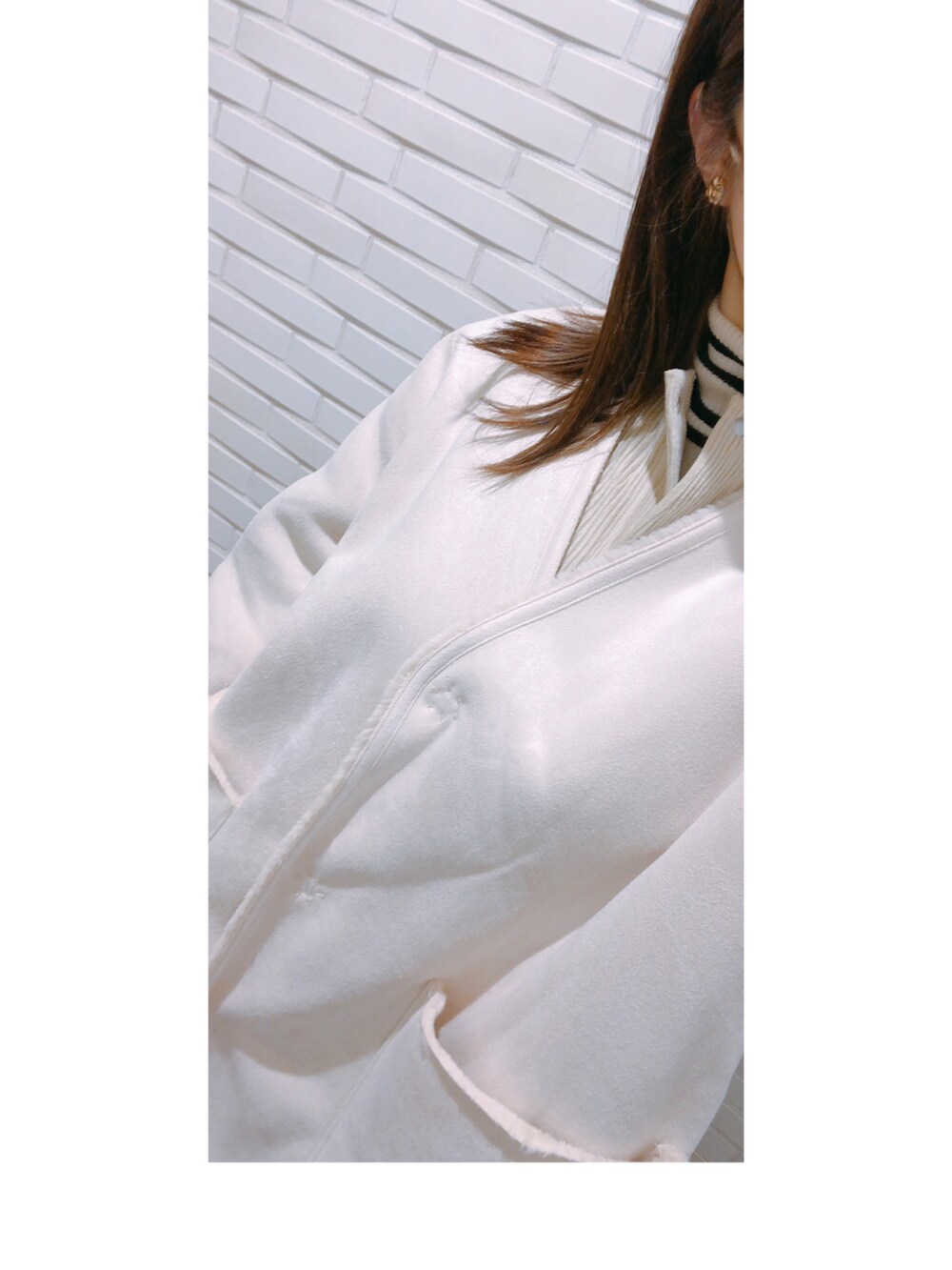 ブラック系のパンツ、ブラック系のパンプス、ホワイト系のバッグを着用したレディースの冬コーディネートの2枚目の写真