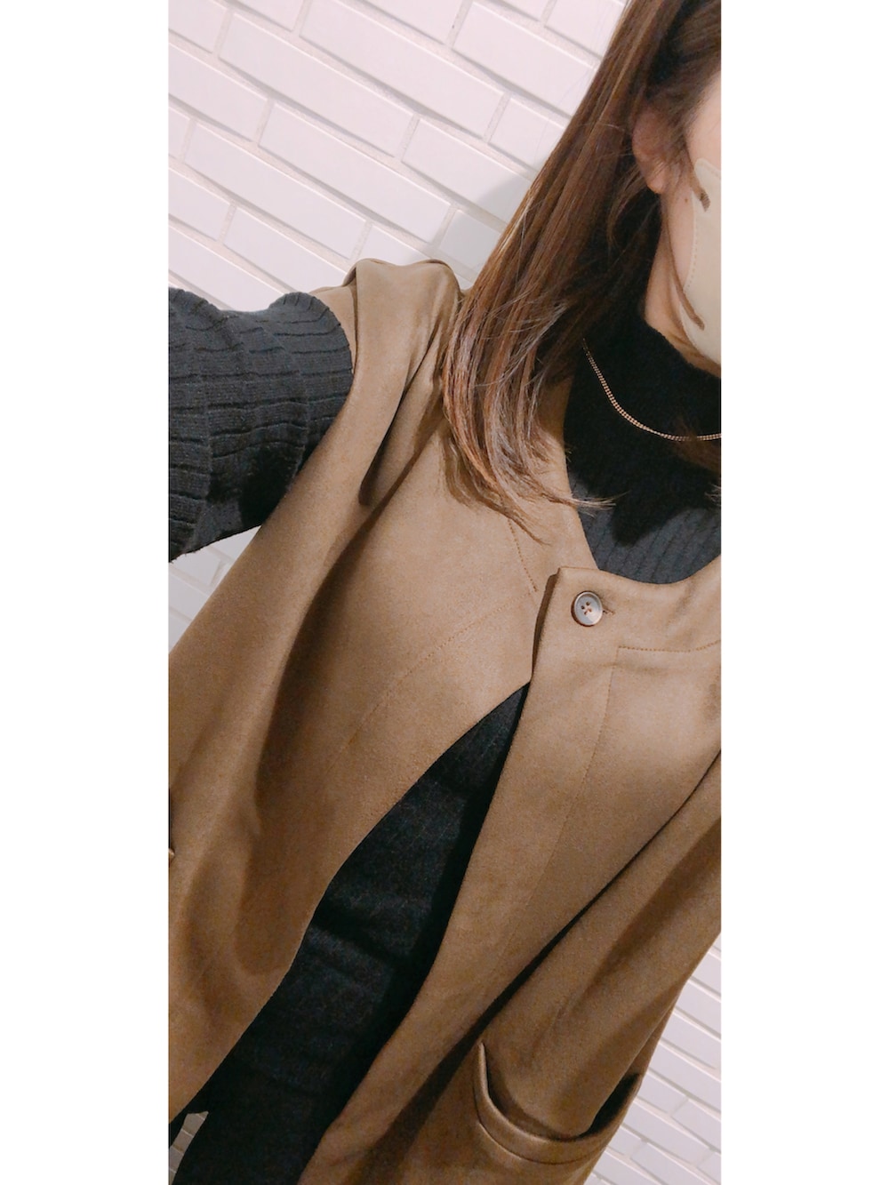 ブラウン系のバッグ、ブラウン系のシューズ、ブラック系のパンツを着用したレディースの冬コーディネートの4枚目の写真