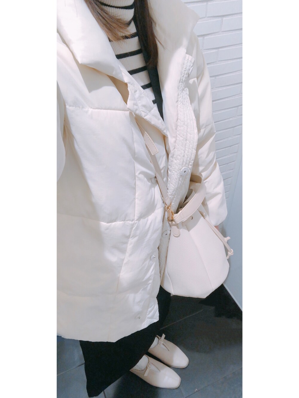 ブラック系のジャンパースカート、ホワイト系のニット/セーターを着用したレディースの冬コーディネートの3枚目の写真