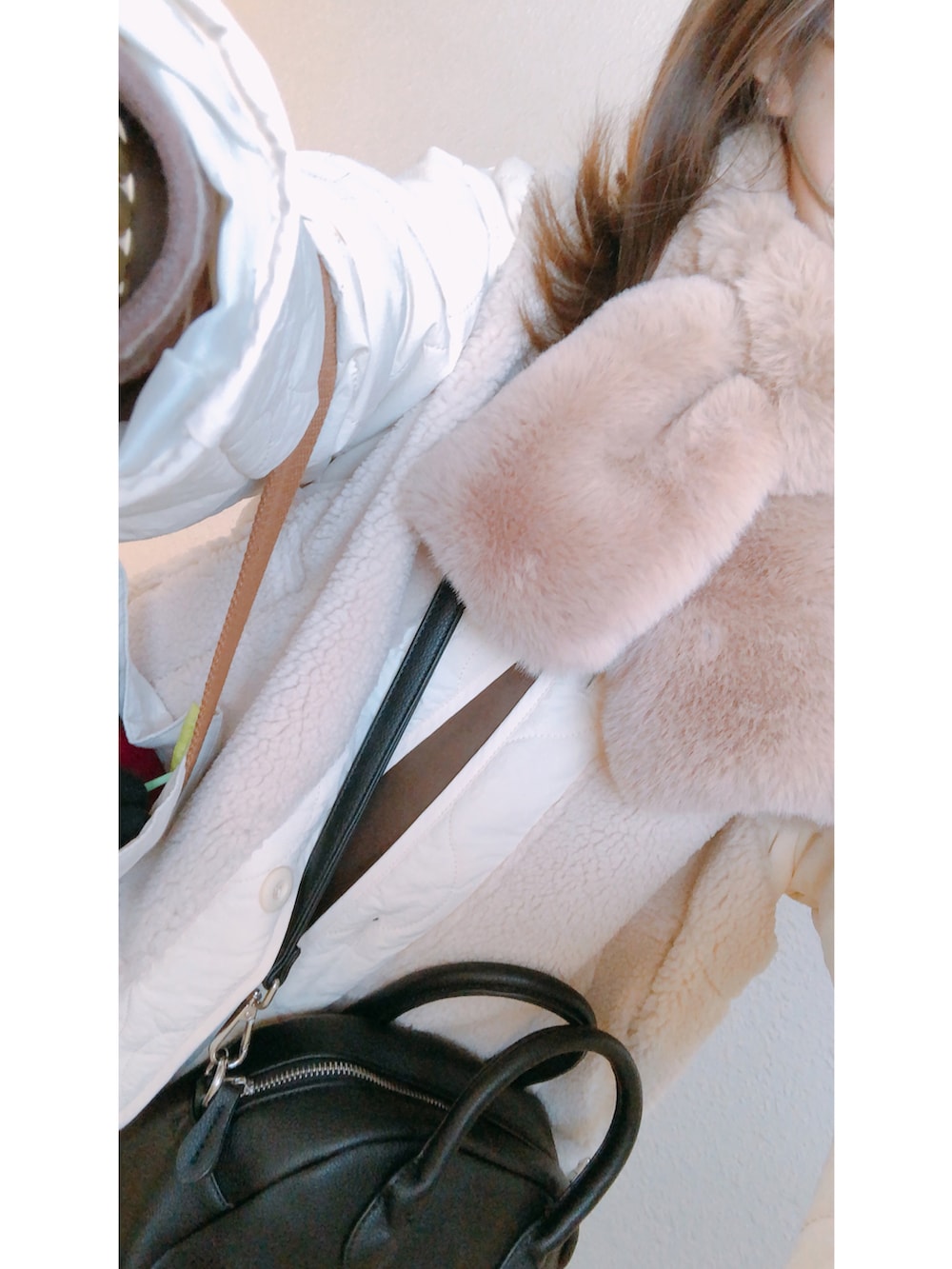 ブラック系のボストンバッグ、ホワイト系のブルゾン、ブラック系のスカートを着用したレディースの冬コーディネートの2枚目の写真