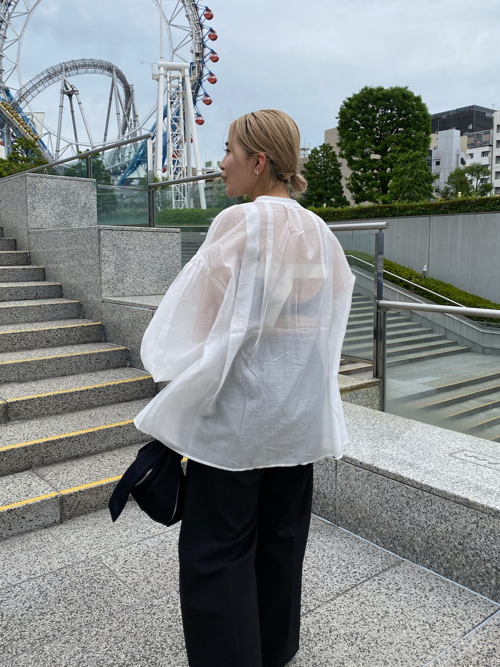 イエロー系のハンドバッグ、ブラック系のその他パンツ、ブラック系のサンダルを着用したレディースの夏コーディネートの4枚目の写真