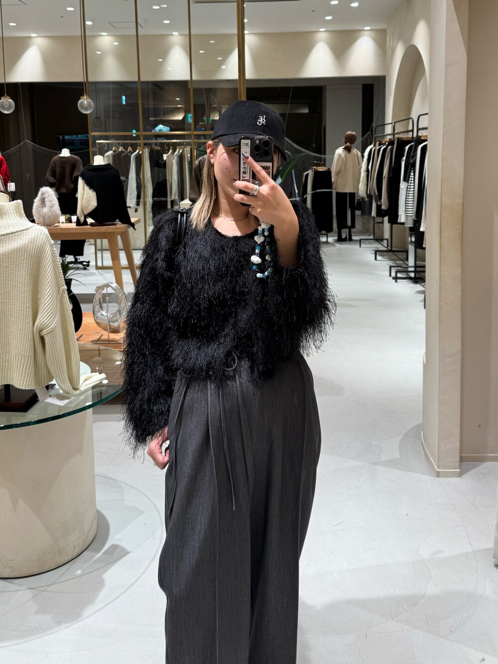 ブラック系のニット/セーター、ブラック系のその他パンツ、ブラック系のショルダーバッグを着用したレディースの冬コーディネートの2枚目の写真