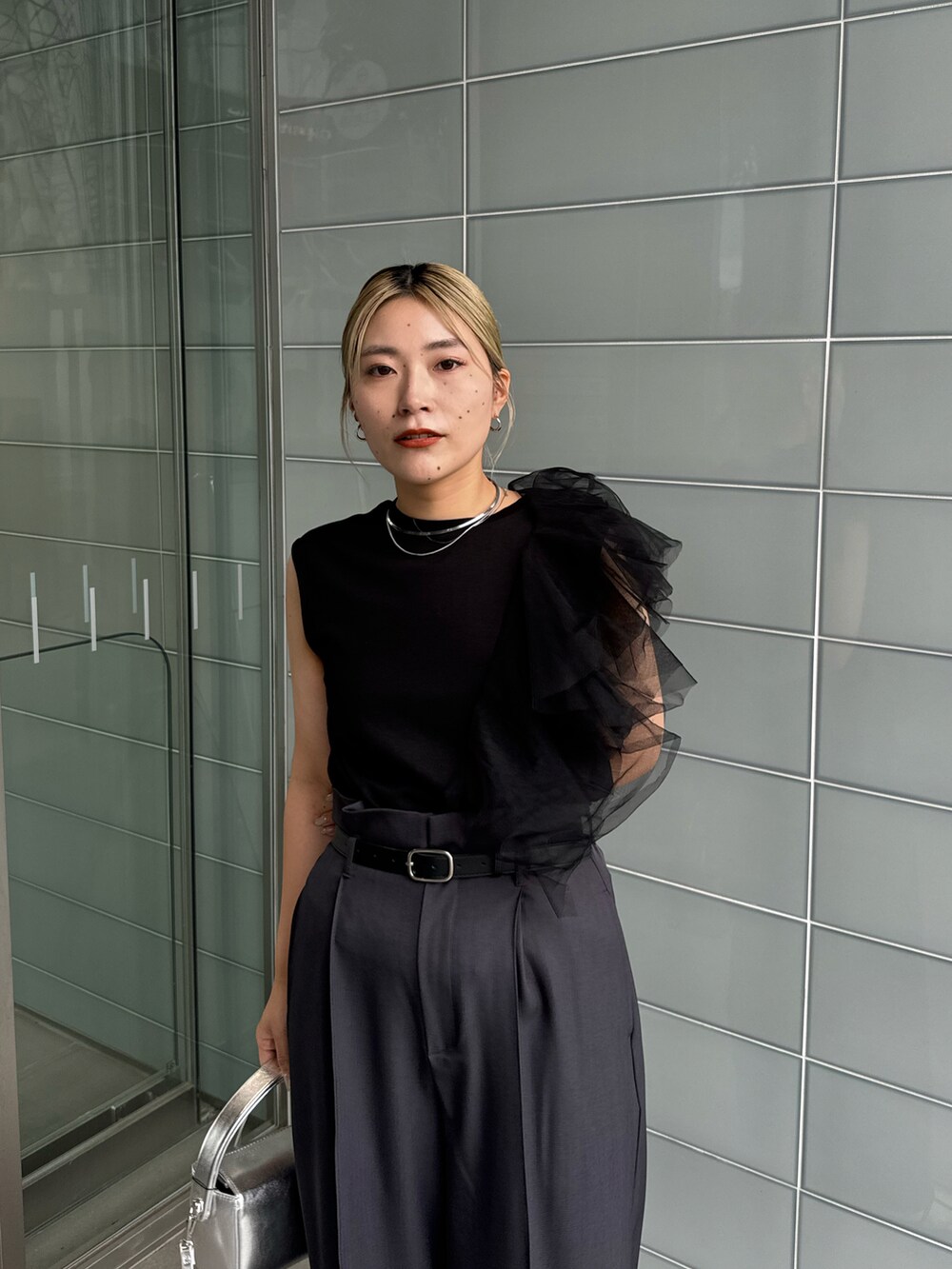 ブラック系のTシャツ/カットソー、グレー系のその他パンツ、シルバー系のショルダーバッグを着用したレディースの夏コーディネートの2枚目の写真