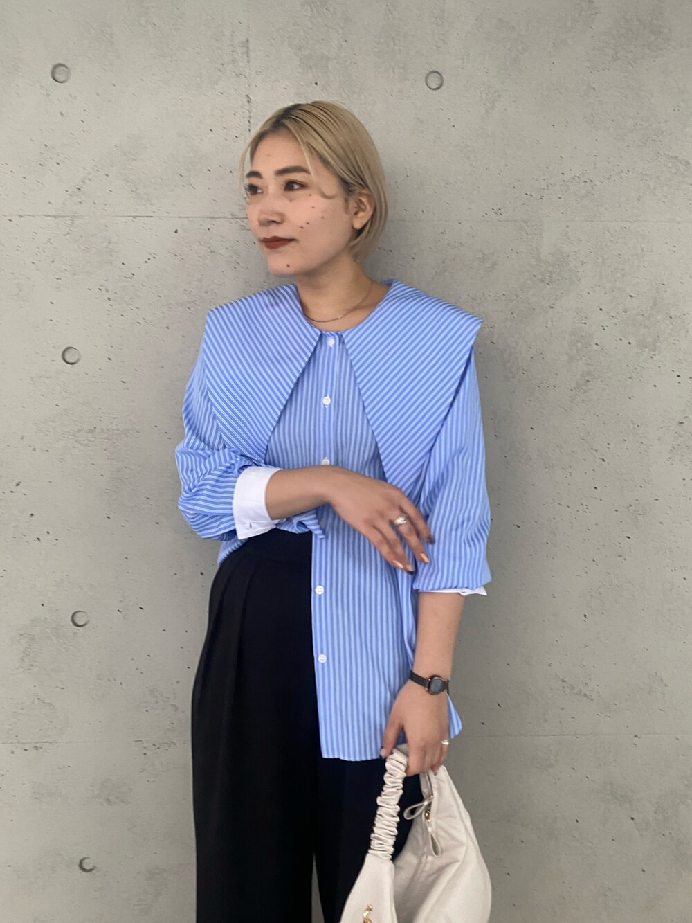 ホワイト系のハンドバッグ、ブルー系のシャツ/ブラウス、ブラック系のその他パンツを着用したレディースの冬コーディネートの2枚目の写真