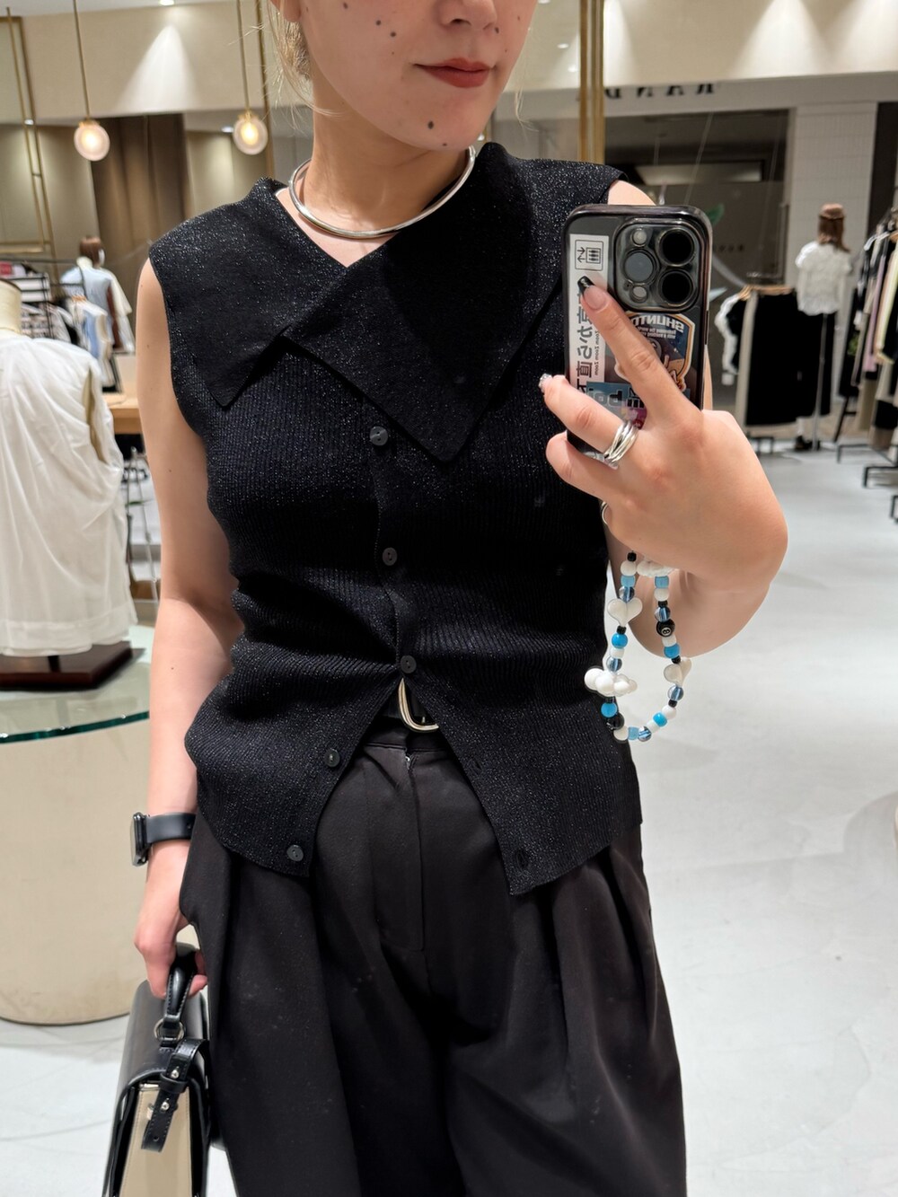 ブラック系のニット/セーター、ブラック系のショルダーバッグ、ブラック系のその他パンツを着用したレディースの夏コーディネートの3枚目の写真