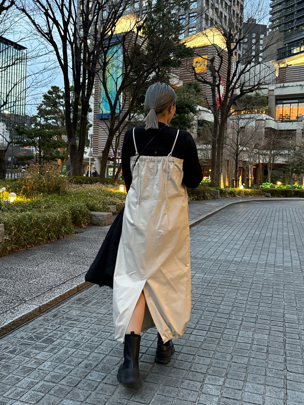 ブラック系のブーツ、ホワイト系のワンピース、ブラック系のニット/セーターを着用したレディースの冬コーディネートの2枚目の写真