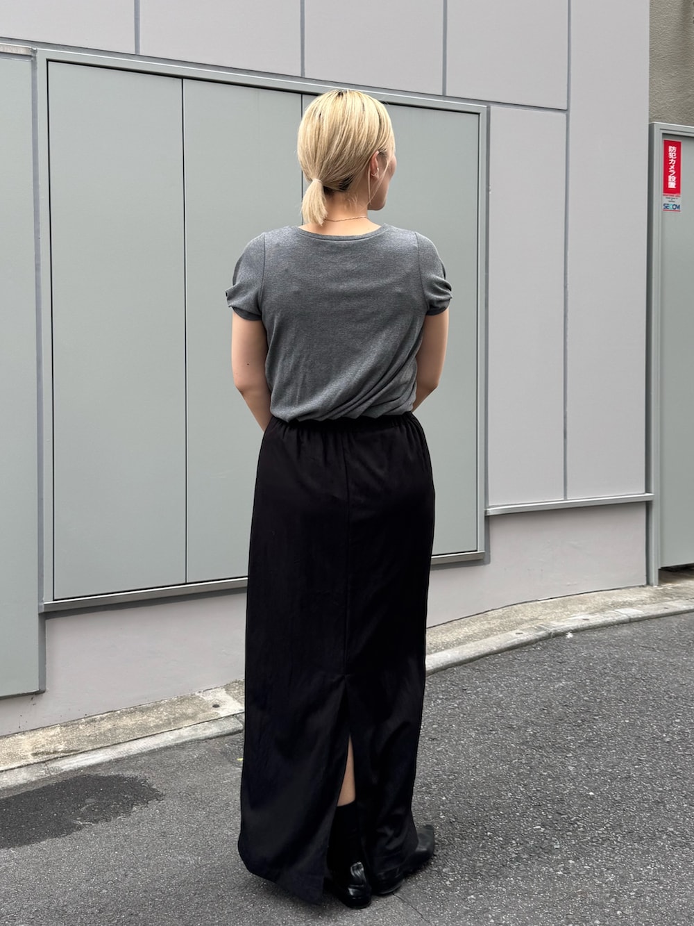 ブラック系のショルダーバッグ、ブラック系のローファー、ブラック系のスカートを着用したレディースの夏コーディネートの2枚目の写真
