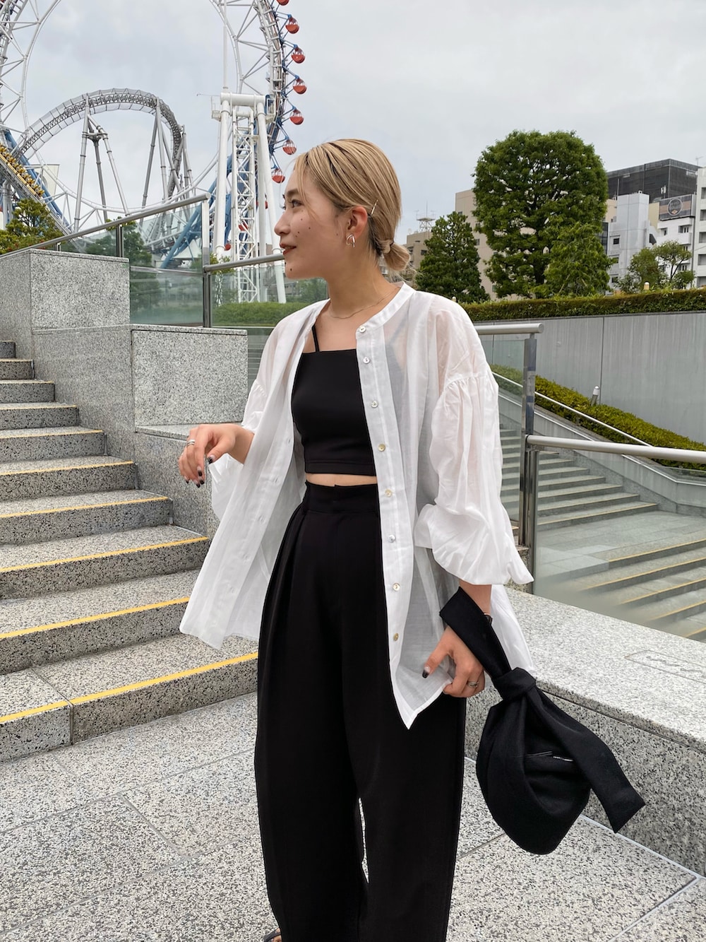 イエロー系のハンドバッグ、ブラック系のその他パンツ、ブラック系のサンダルを着用したレディースの夏コーディネートの3枚目の写真